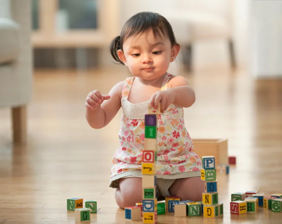 a baby sitting on a floor