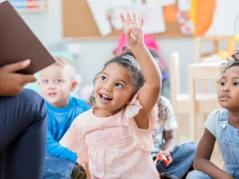 a group of children raising their hands