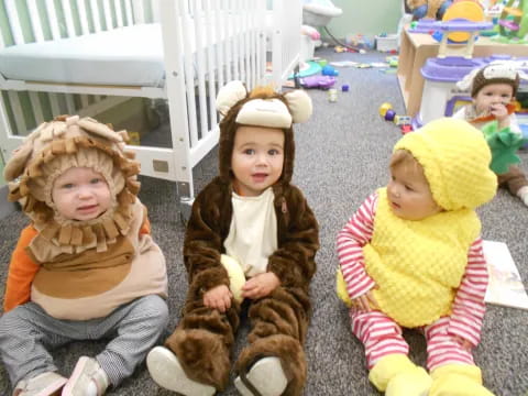 a group of children sitting on the ground with a stuffed animal