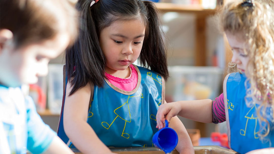 a young girl holding a blue cup