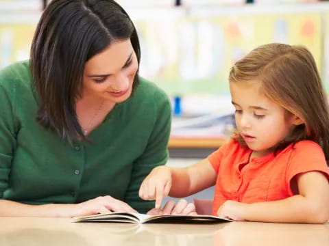 a woman and a child looking at a book