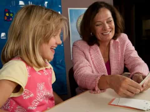 a person and a child looking at a paper