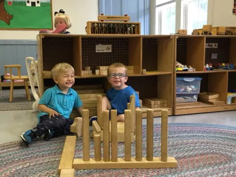 two boys sitting on a wooden structure