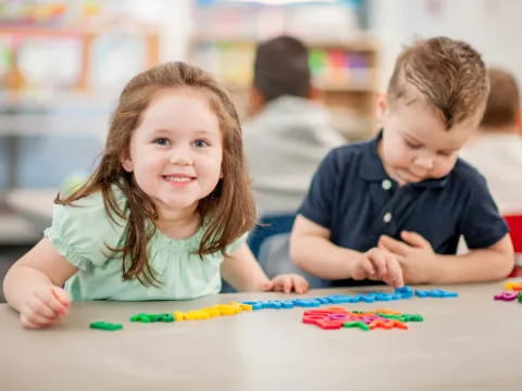a boy and girl playing with colorful paper