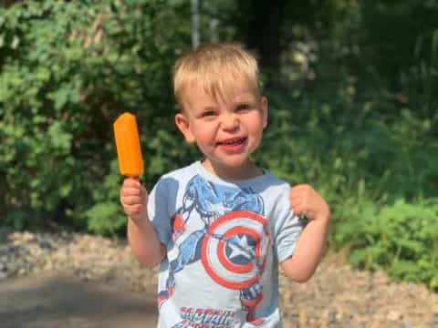 a boy holding a carrot