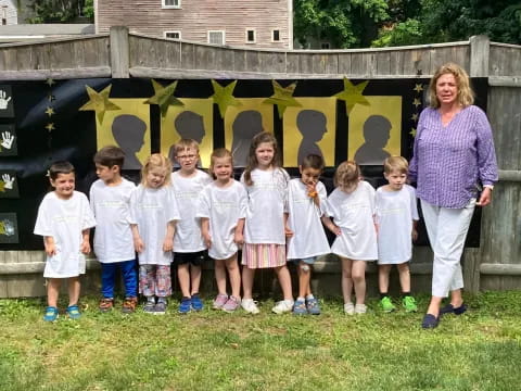 a group of children posing for a photo in front of a sign