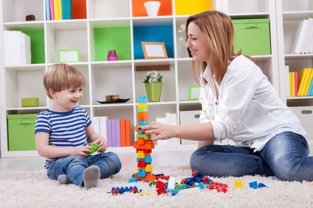 a person and a child playing with toys on the floor