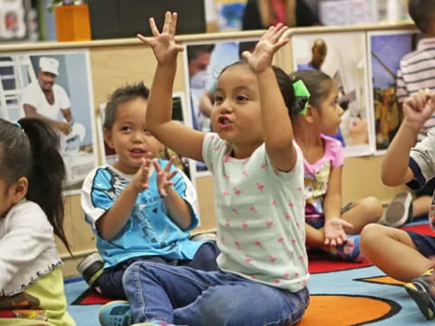 a group of children raising their hands