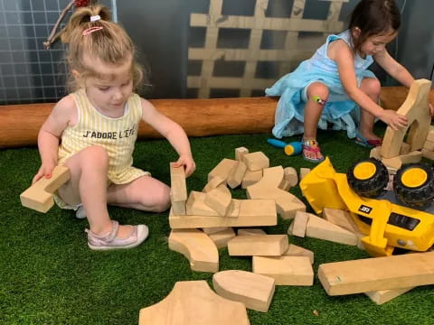 a couple of girls playing with blocks