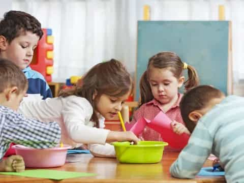 a group of children sitting around a table