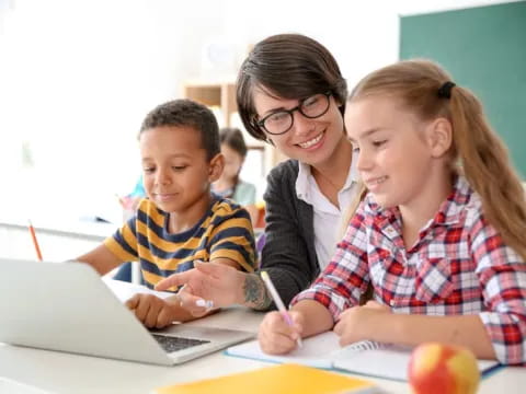 a teacher and her students working on a laptop