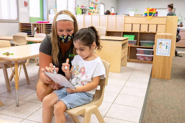 a person and a child sitting in a chair in a library