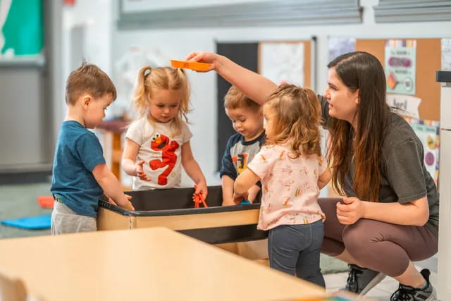 a person and kids playing with a toy