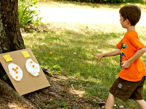a boy pointing to a box with a sticker on it