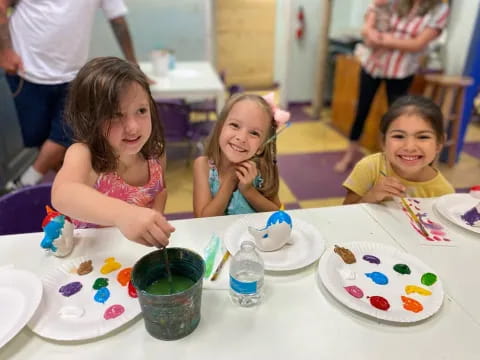 a group of children sitting at a table with cake