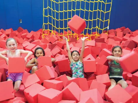 a group of children in a large red and blue play structure