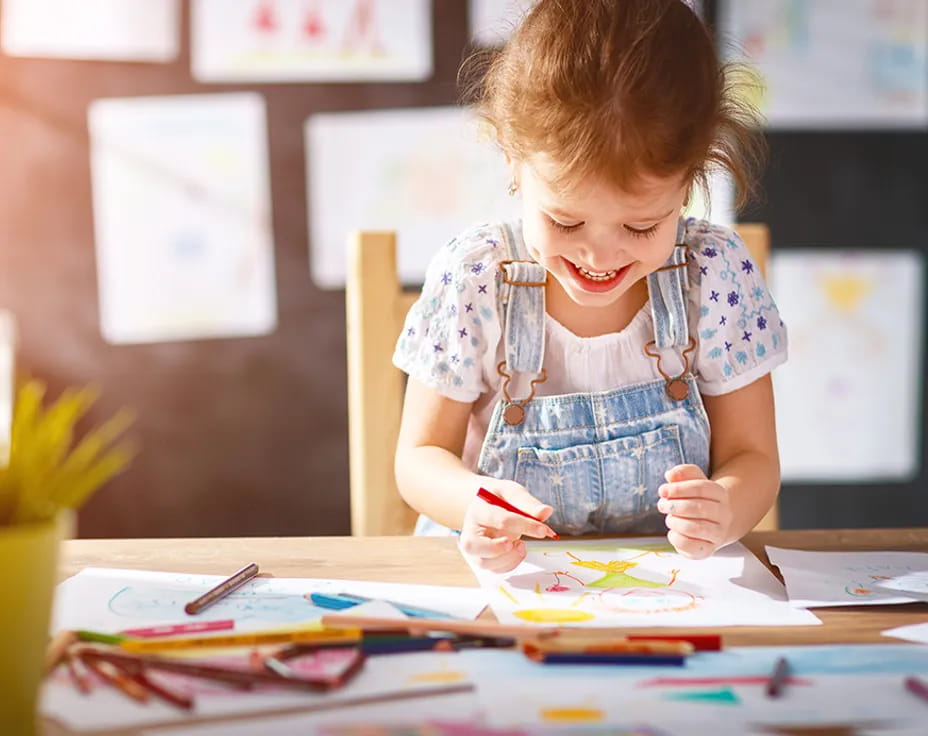 a young girl coloring on a table