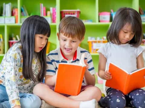 a group of children sitting on the floor reading books