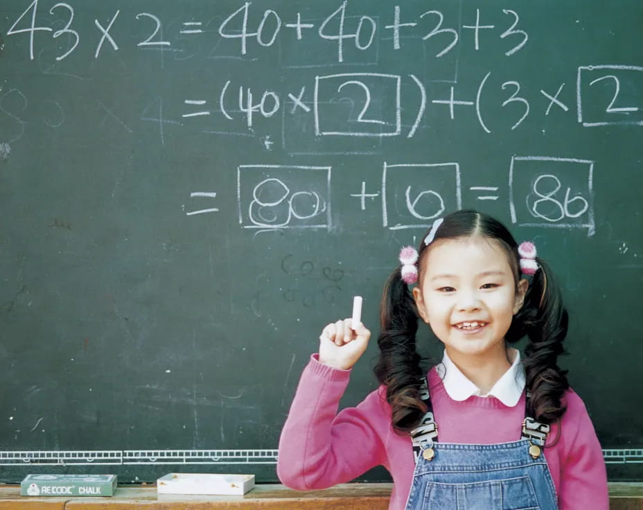 a girl standing in front of a chalkboard