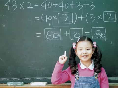 a girl standing in front of a chalkboard