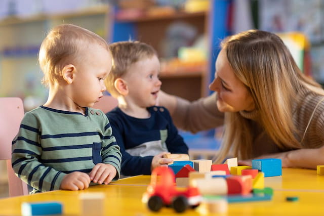 a person and two children playing with a toy train