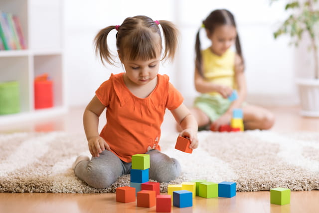 a couple of children playing with blocks
