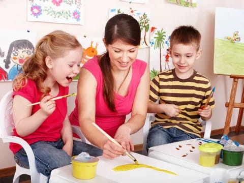 a person and two children painting