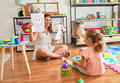 a person and two children playing with toys in a room
