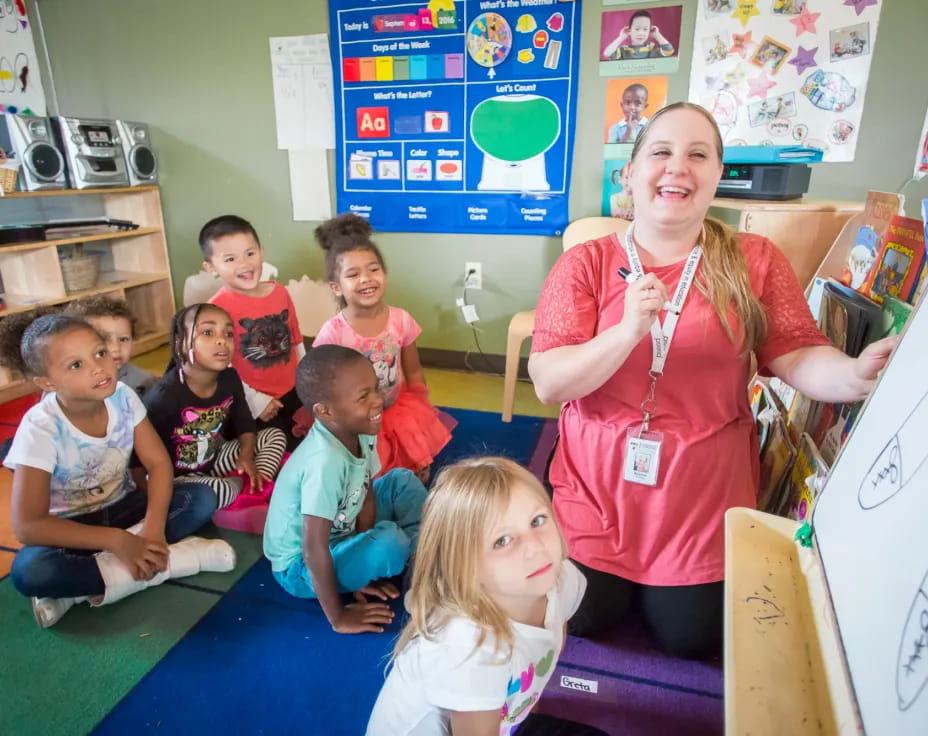 a person and a group of children in a classroom