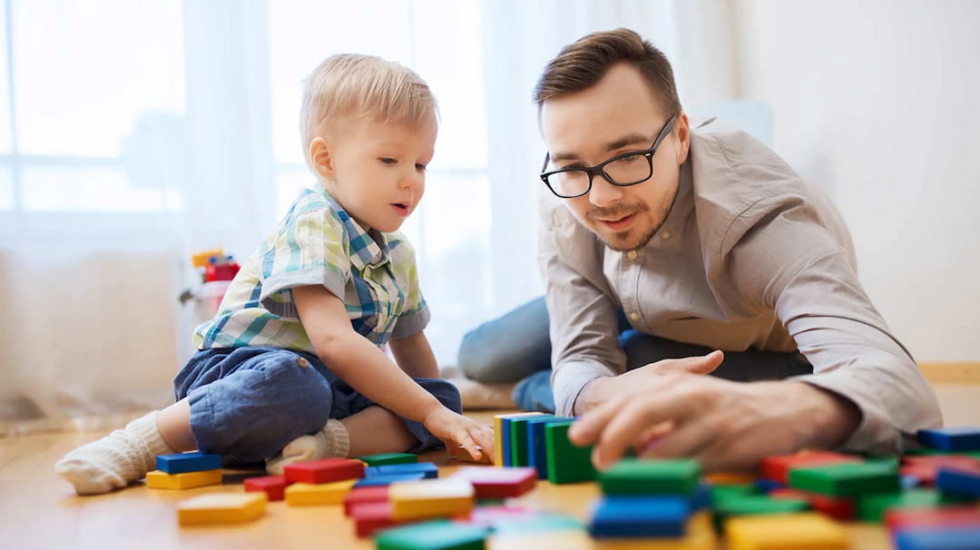 a person and a baby playing with blocks