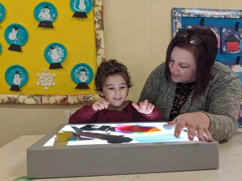 a person and a child looking at a book