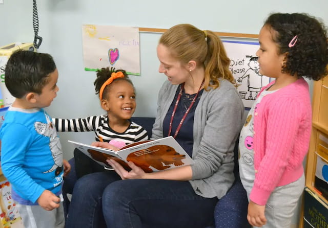 a teacher reading a book to her students