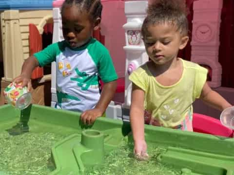 a couple of children playing in a water fountain