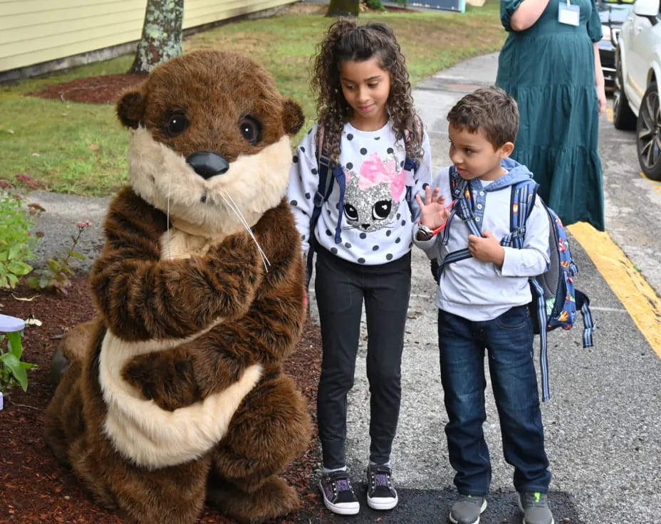 a person and a boy standing next to a person in a bear garment