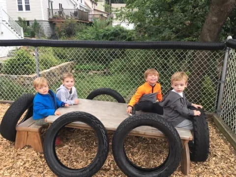 a group of kids sitting on a wooden toy tractor