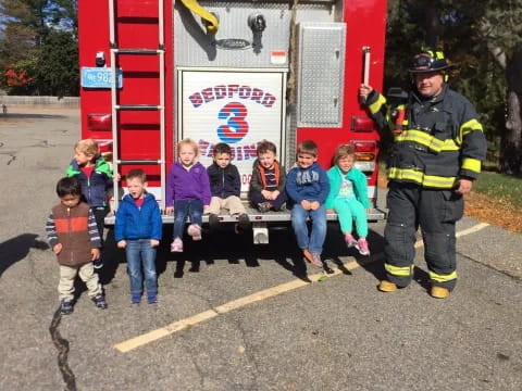 a firefighter standing next to a group of children