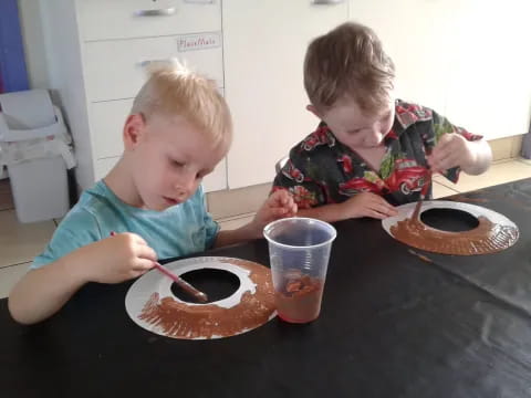two boys eating cake