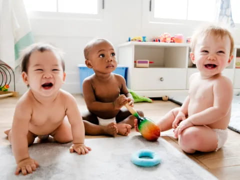 a group of babies sitting on the floor eating