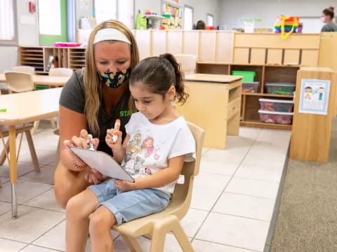 a person and a child sitting in a chair in a library