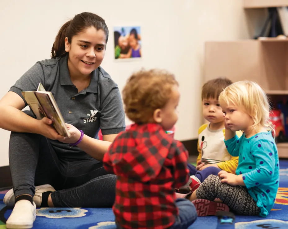 a person reading a book to a few children