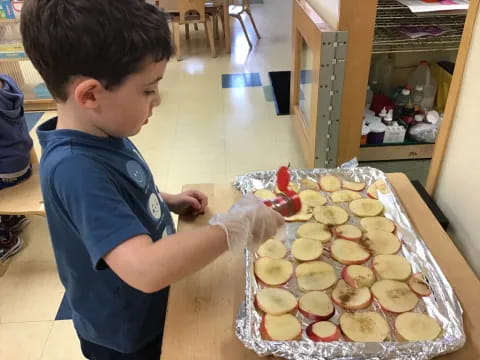 a boy looking at a tray of pastries