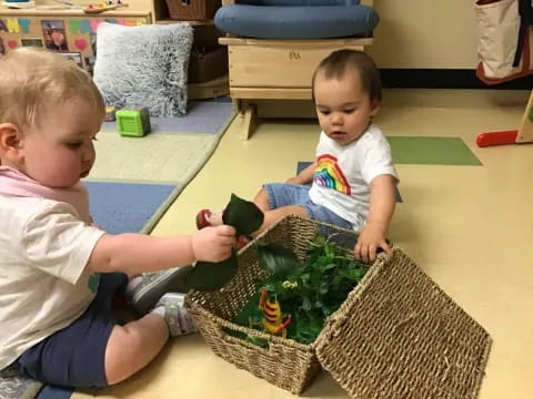 a couple of babies playing with a toy