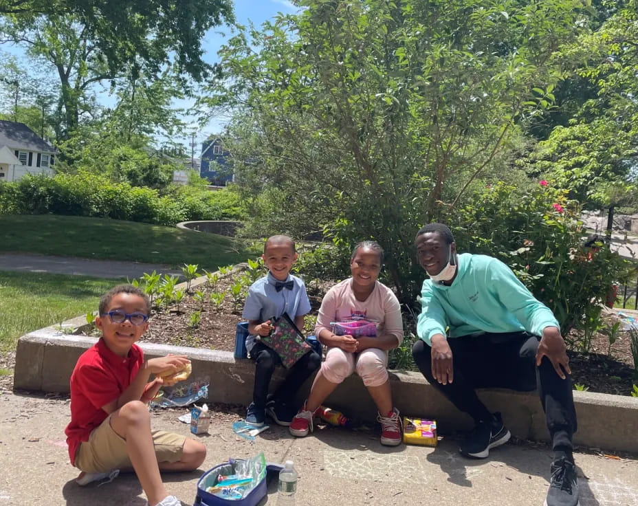 a group of people sitting on a bench outside