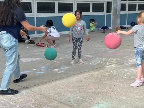 a person and children playing with balloons