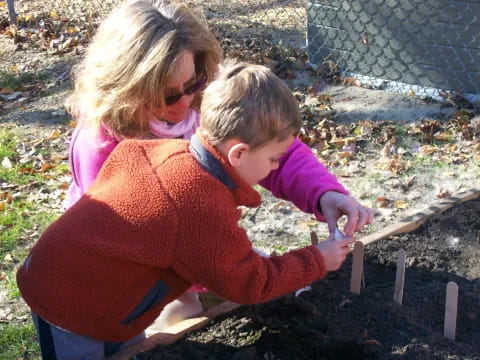 a person and a child planting a tree