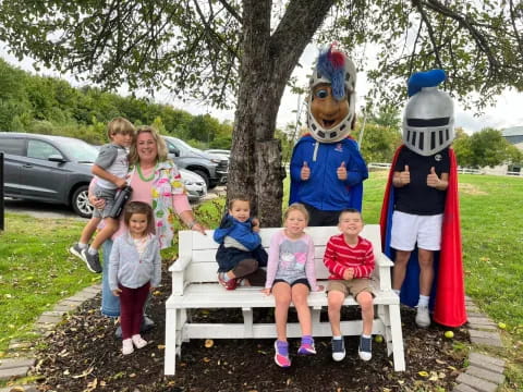 a group of kids posing with a person in a garment