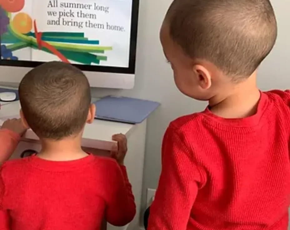 a couple of boys sitting in front of a blackboard