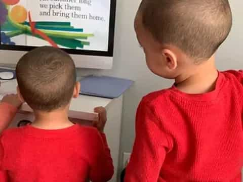 a couple of boys sitting in front of a blackboard