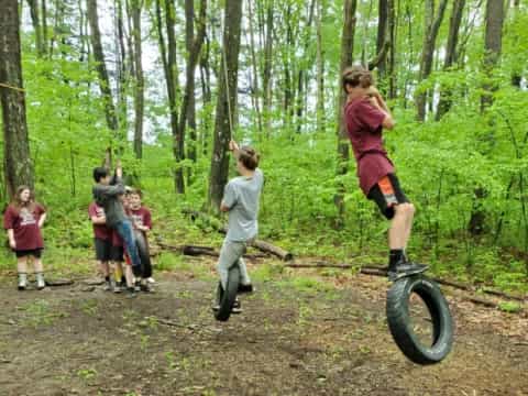 a group of people on a tire swing in the woods