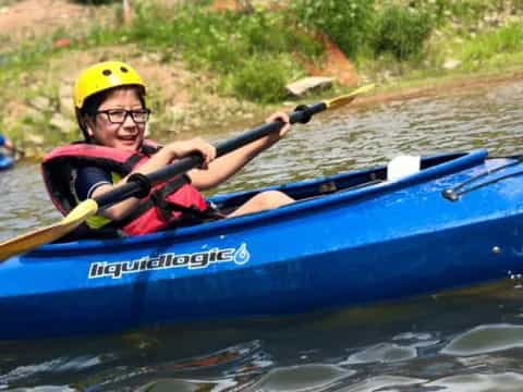 a boy in a blue kayak